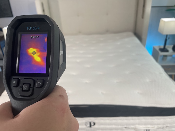 a man points a heat gun toward the PlushBeds Signature Bliss mattress
