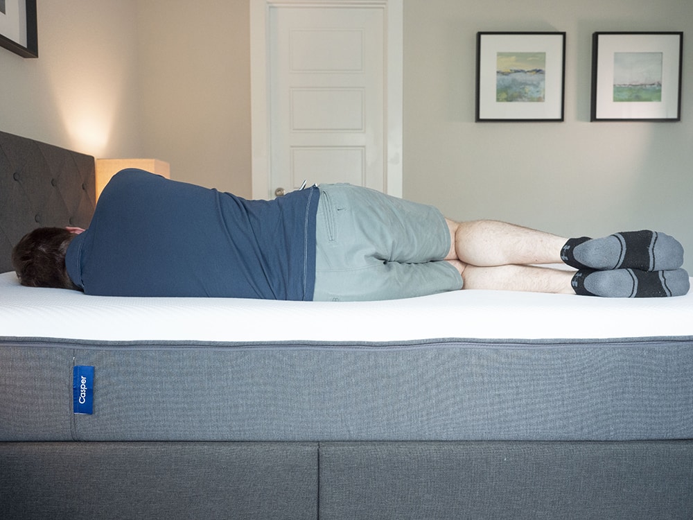 A man sleeps on his side on a Casper mattress