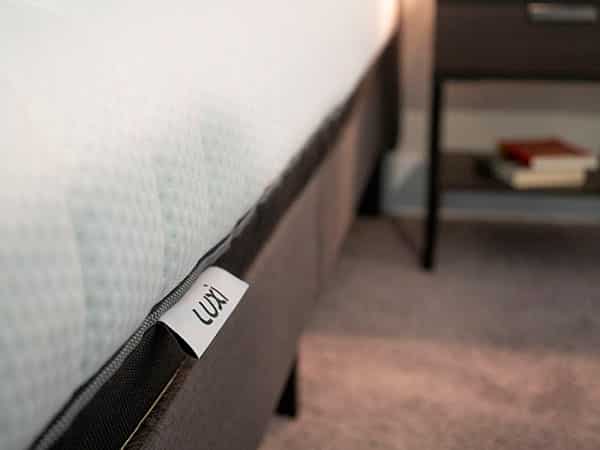 A mattress sits on a modern frame.