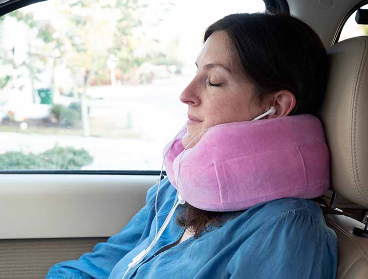woman asleep with pink Cabeau Evolution travel pillow in car