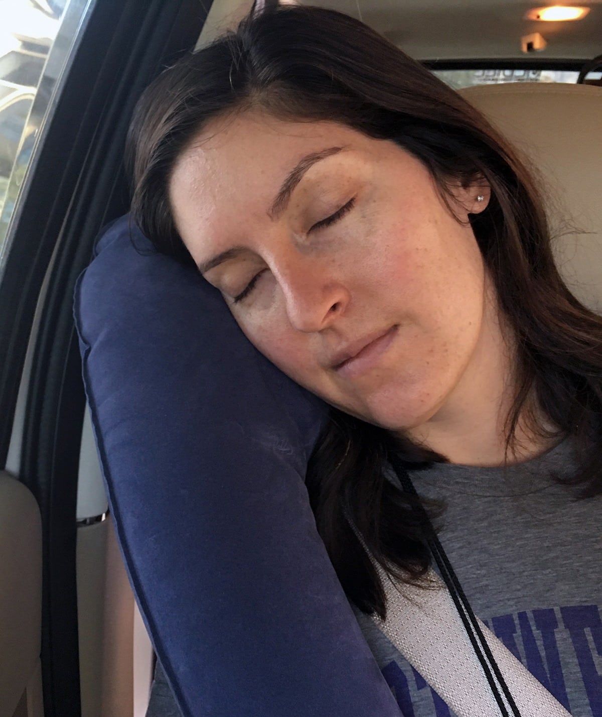 woman using the Travelrest Ultimate Inflatable Travel Pillow in car