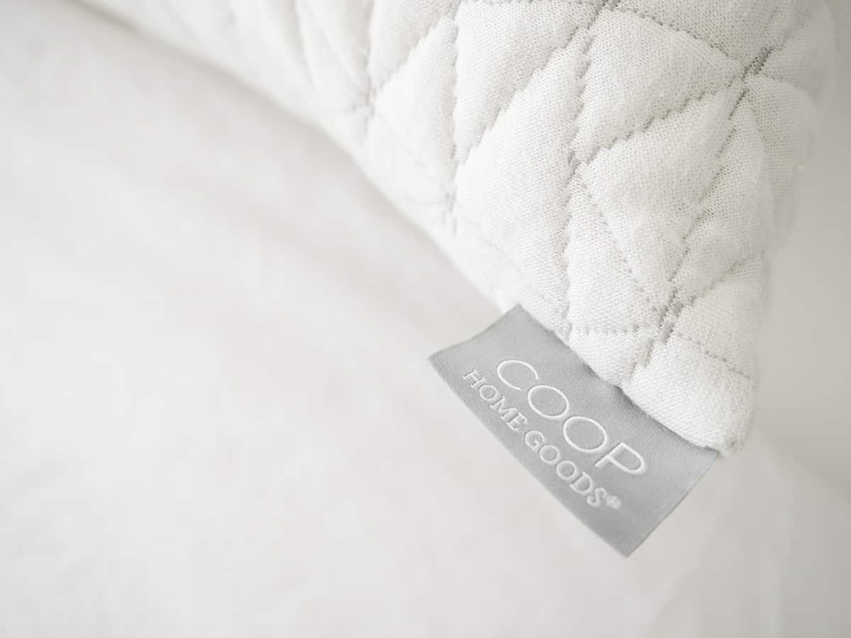 A Coop Home Goods tag displayed on the corner of an Original Pillow