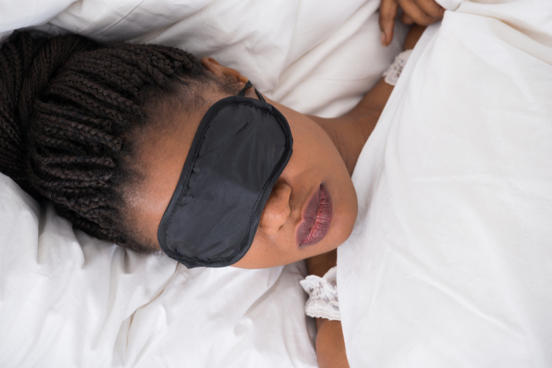 A woman sleeps with a mask on her face.