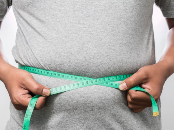 A man measures his belly.