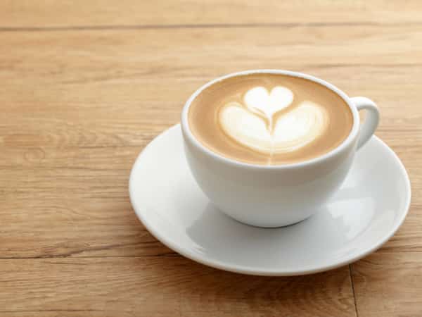 A coffee cup sits on a wooden table.