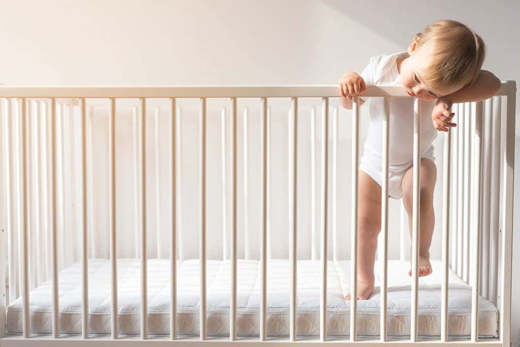 Toddler hanging out of crib