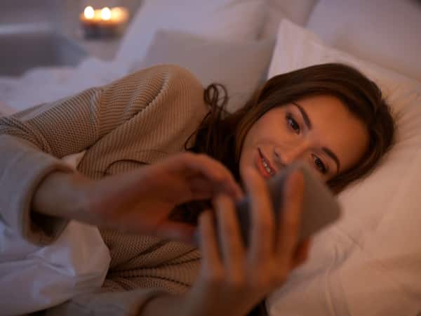 A woman texts in bed.