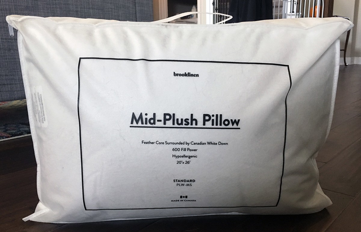 A Brooklinen Mid-Plush Down Pillow sits in its bag. 