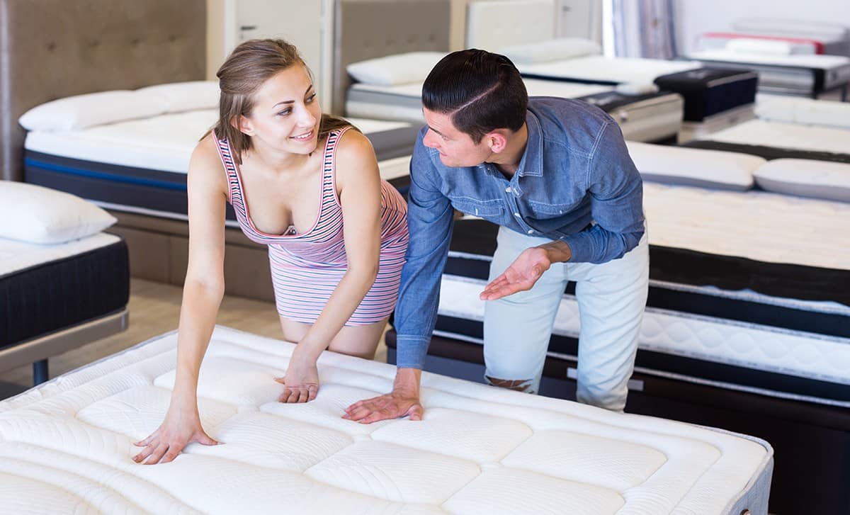 man and woman test mattress firmness