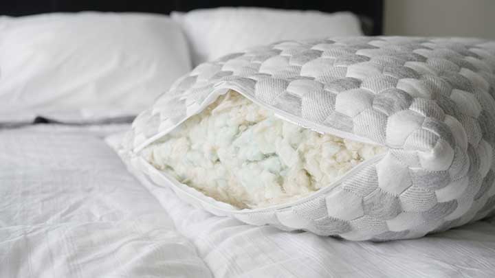 An open Layla Kapok Pillow sits on a bed. 