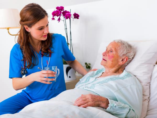 A nurse helps an elderly patient.