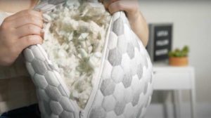 A woman opens the Layla Kapok pillow, revealing the shredded foam inside.
