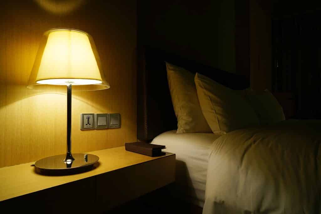 a bedroom light is on in a dark bedroom