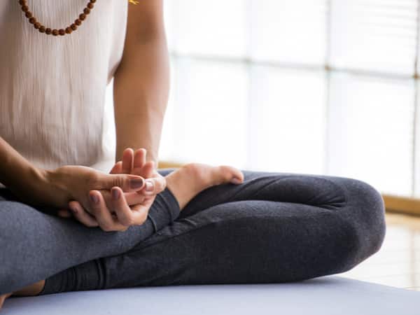 A woman sits with her legs crossed.