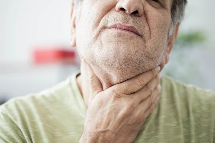 a man struggles with a sore throat