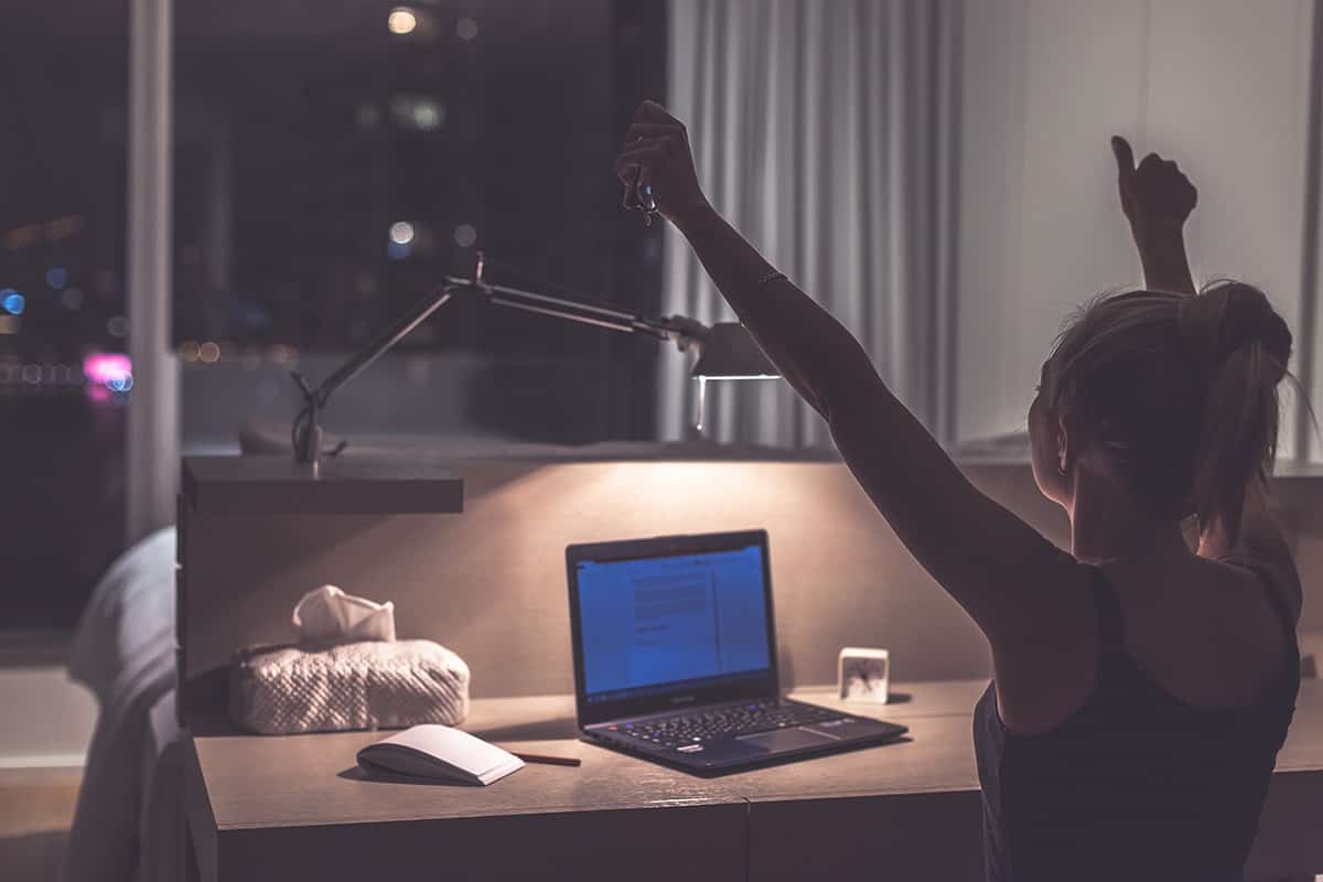 A woman works at her laptop at night