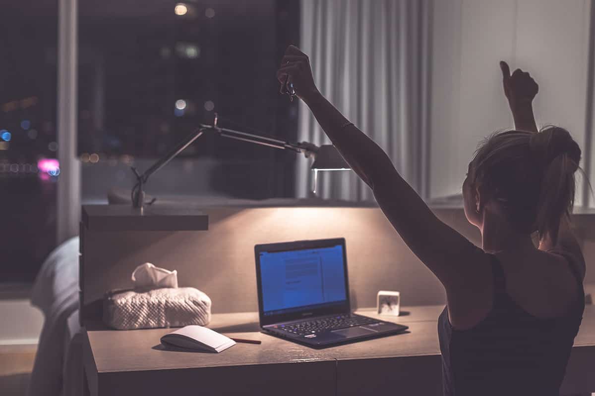 A woman works at her laptop at night A woman works at her laptop at night