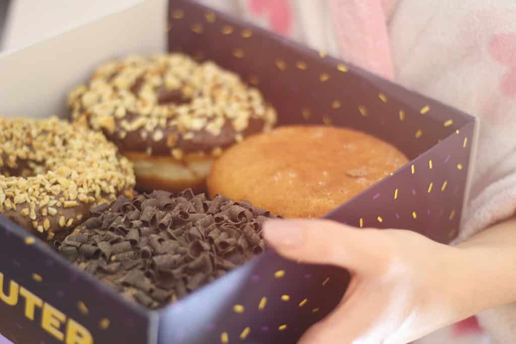 How Does Sugar Affect Sleep? Someone holds a box of donuts