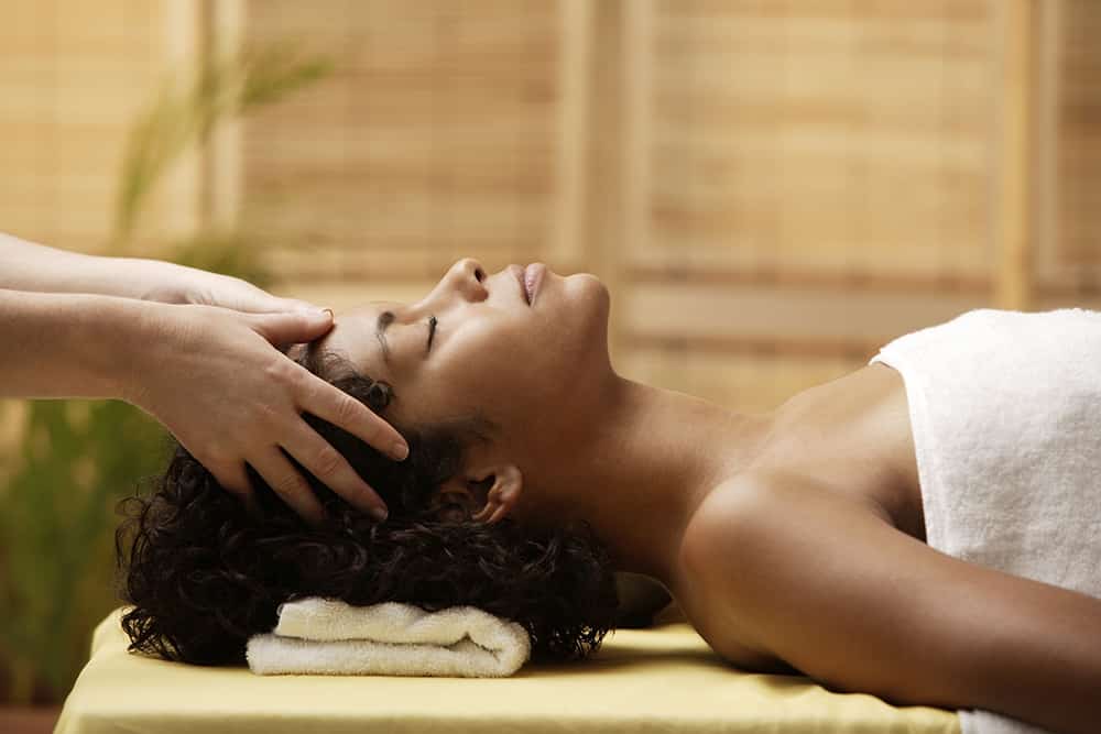 What Is a Sleep Retreat and Should You Take One? Woman gets her head massaged