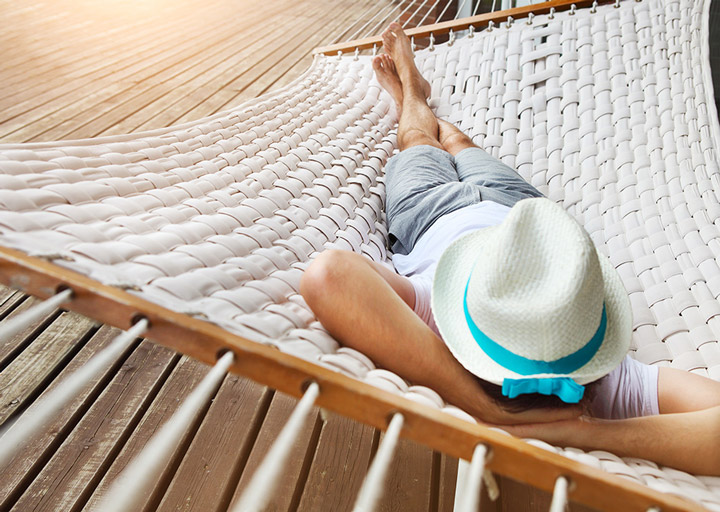 A man lounges on a hammock.