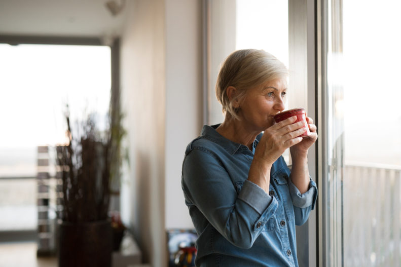 Woman drinking coffee at window