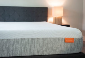 A mattress sits in a modern bedroom.