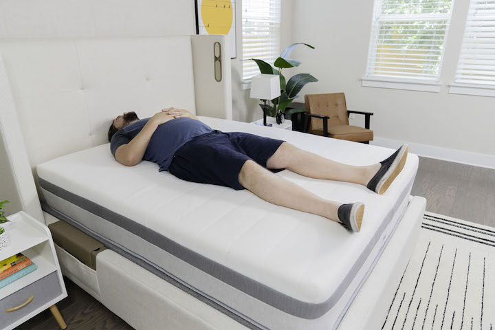 a man sleeps on his back on the Helix Plus mattress
