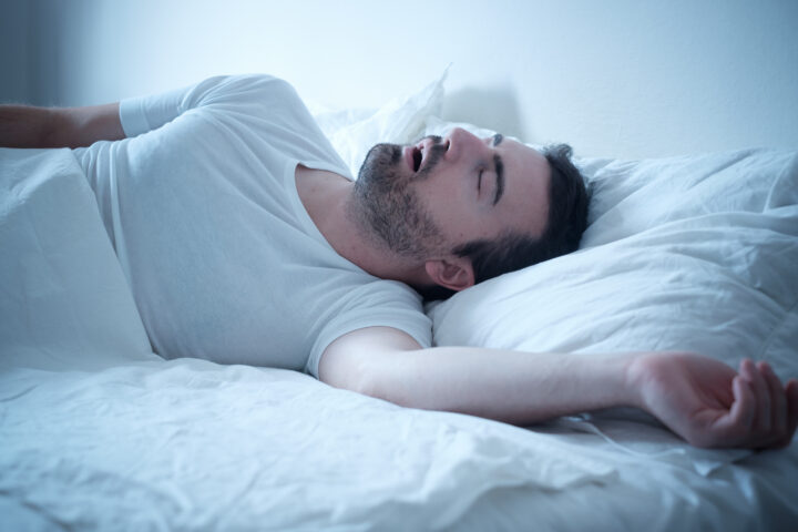 Man sleeping on bed snoring