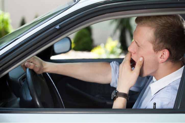 A Man Yawns In His Car