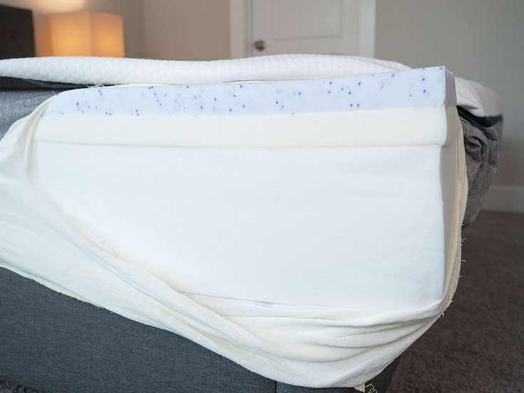 A foam mattress is opened to show its components.