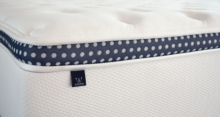 A closeup of a mattress with its tag in frame.
