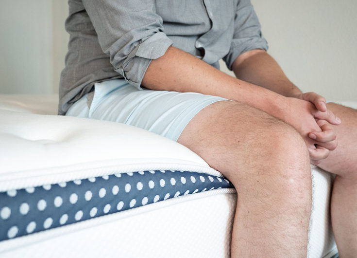 A man sits on the bed.