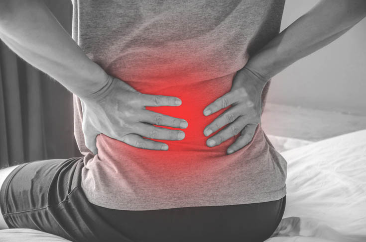 A man holds his lower back because of pain.