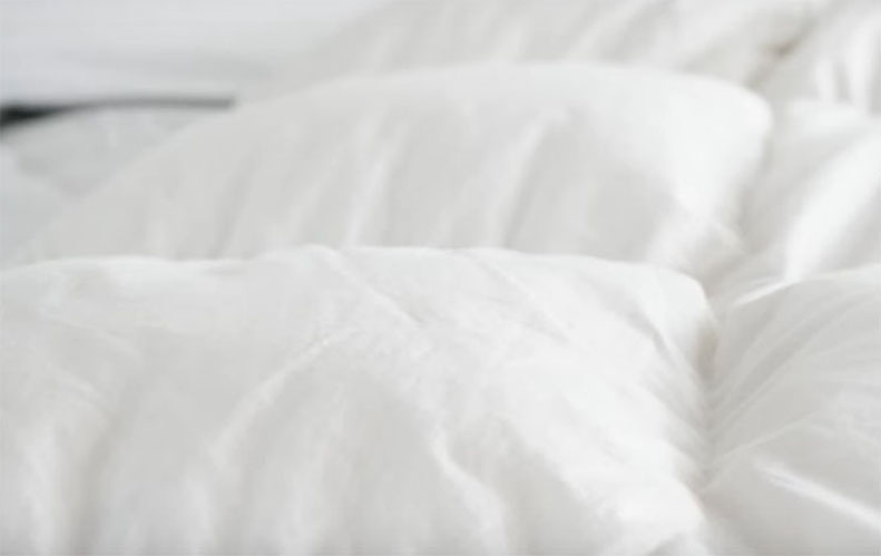 A close picture of a white down comforter.