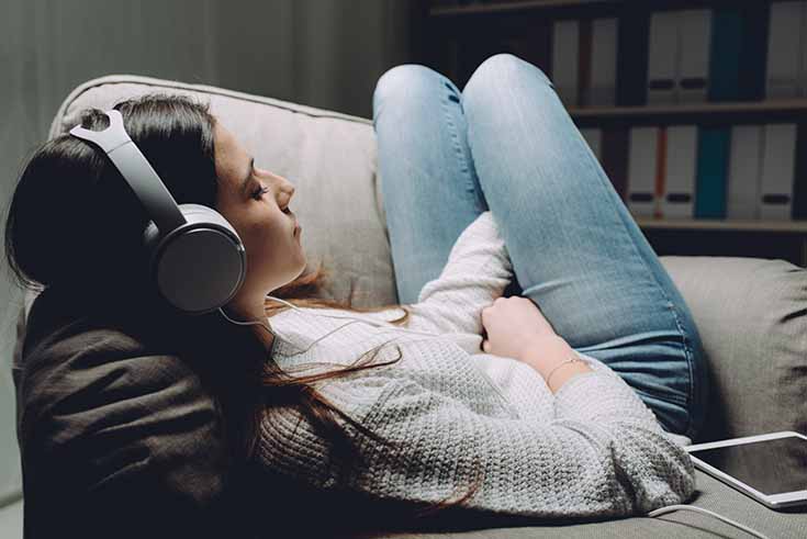 a woman listens to music in her headphones