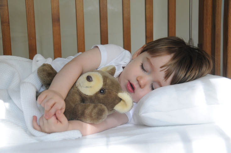 A child sleeps in his crib.