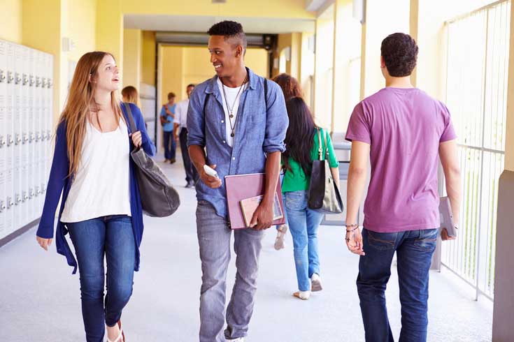 Students walk in a hallway.