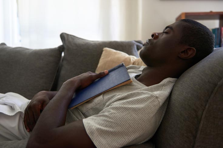 A man sleeps on his couch.