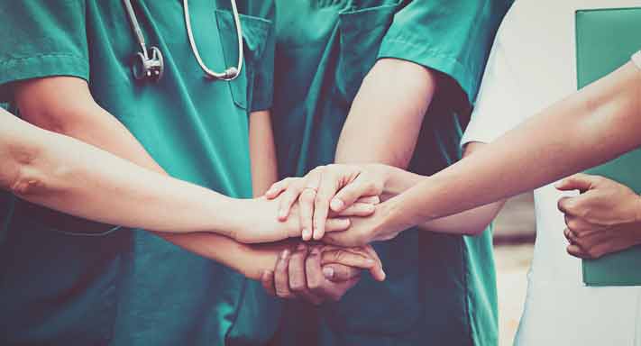 Nurses huddle during a meeting.