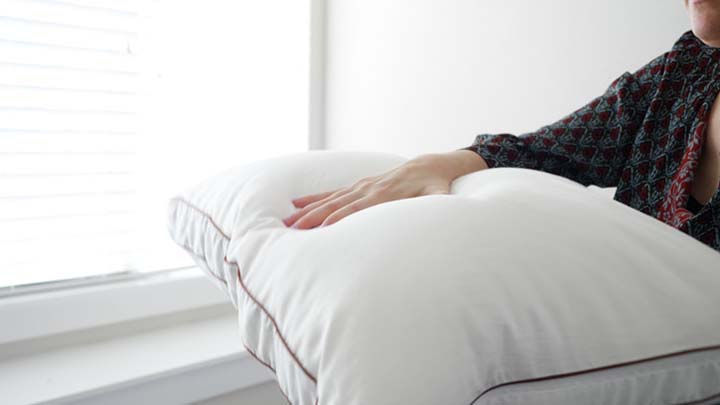 A woman presses on a Saatva Pillow