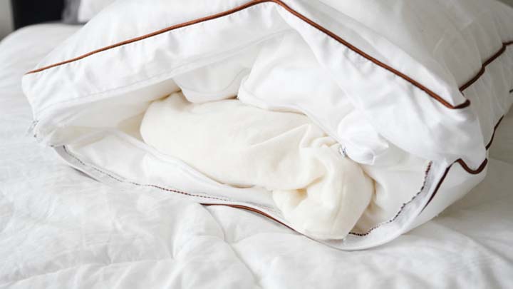 The latex core of the Saatva Pillow peeks out of the pillowcase.