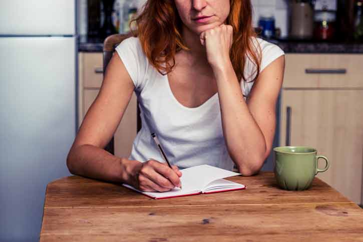 A woman takes notes in her journal.