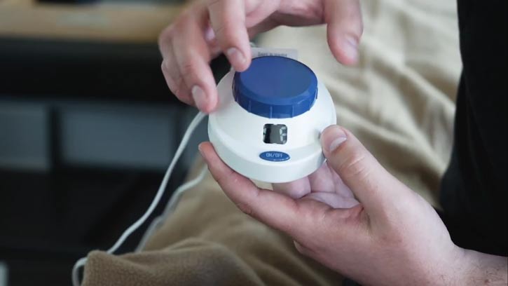 A man holds up an the dial for an electric blanket.