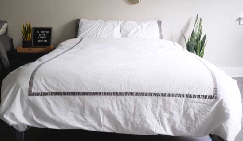 A white duvet cover lies on a mattress.