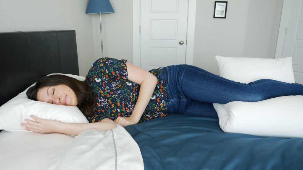 woman sleeping with pillow between her legs