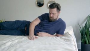 A man lies on a latex mattress topper. A man lies on a latex mattress topper.