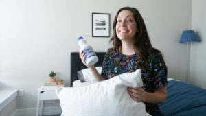 woman holding bleach and pillow