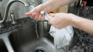 woman squeezing water out of pillow case