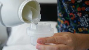 pouring detergent into cap