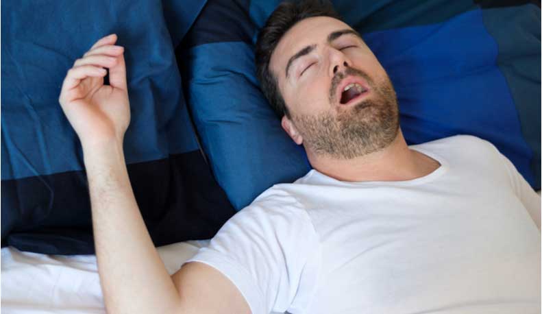 A man snores with his mouth open.
